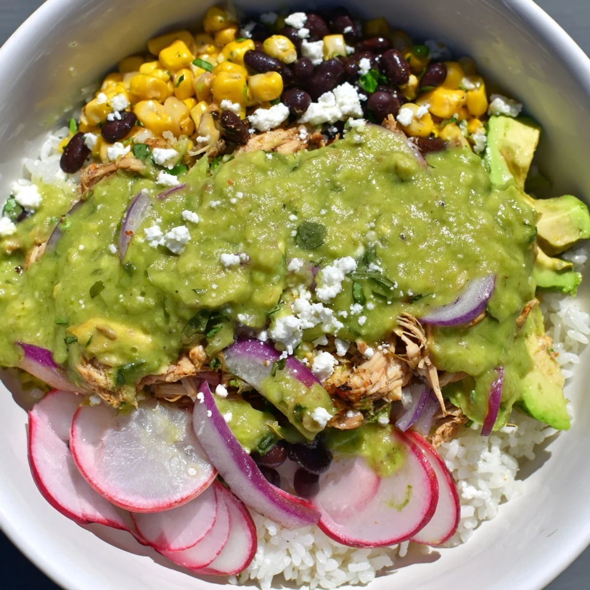 Steaming Green Enchiladas Rice Bowl with vibrant cilantro, avocado, and queso fresco, a delicious Tex-Mex dinner.