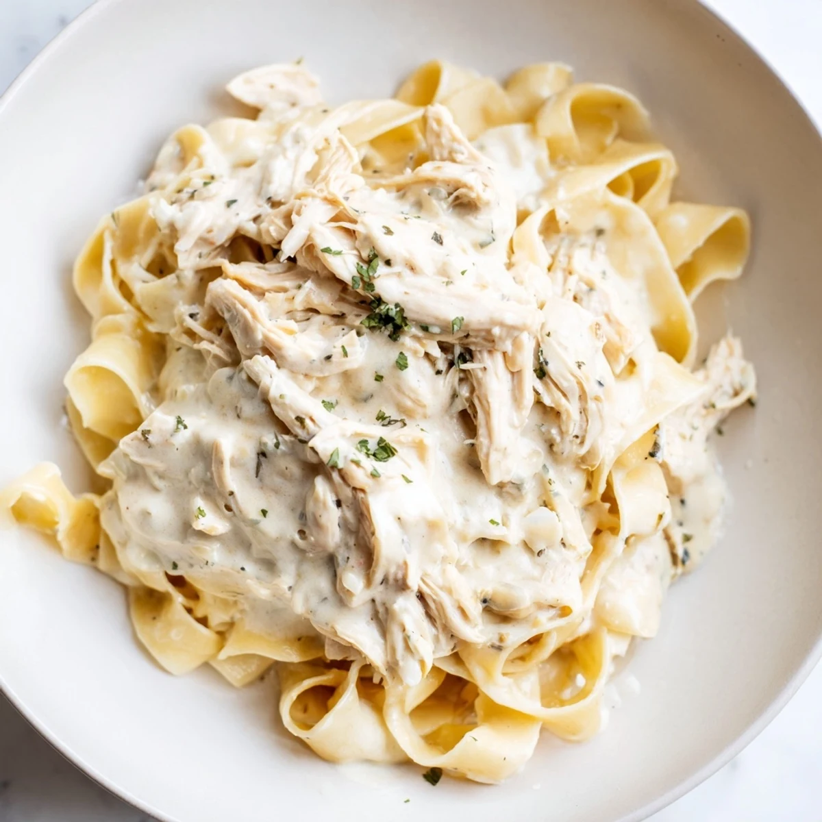 Slow-cooked Creamy Chicken Alfredo, featuring tender chicken in a rich, creamy sauce, ready to serve over pasta.