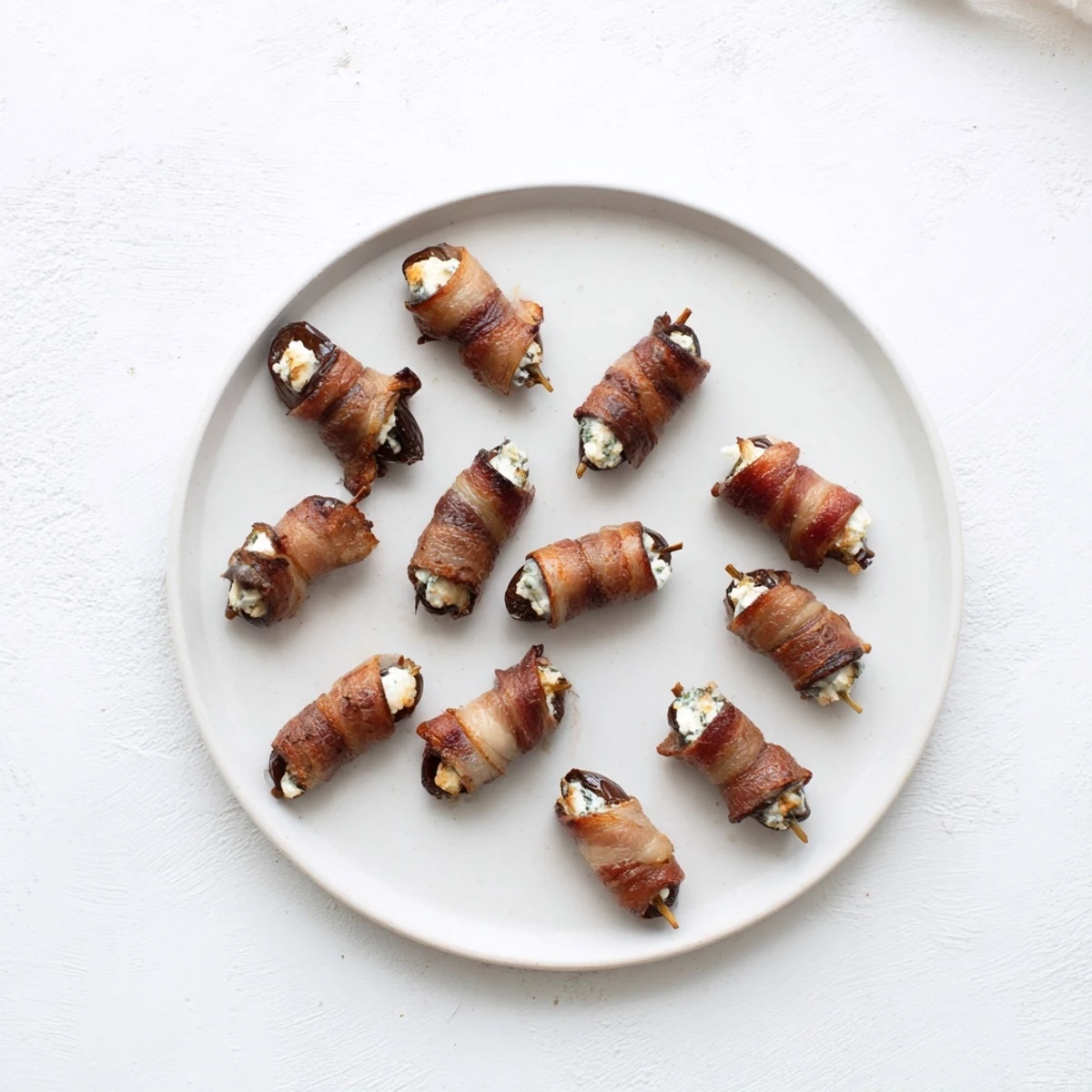 Perfectly cooked bacon blankets creamy goat cheese filling in these delicious bacon-wrapped dates.