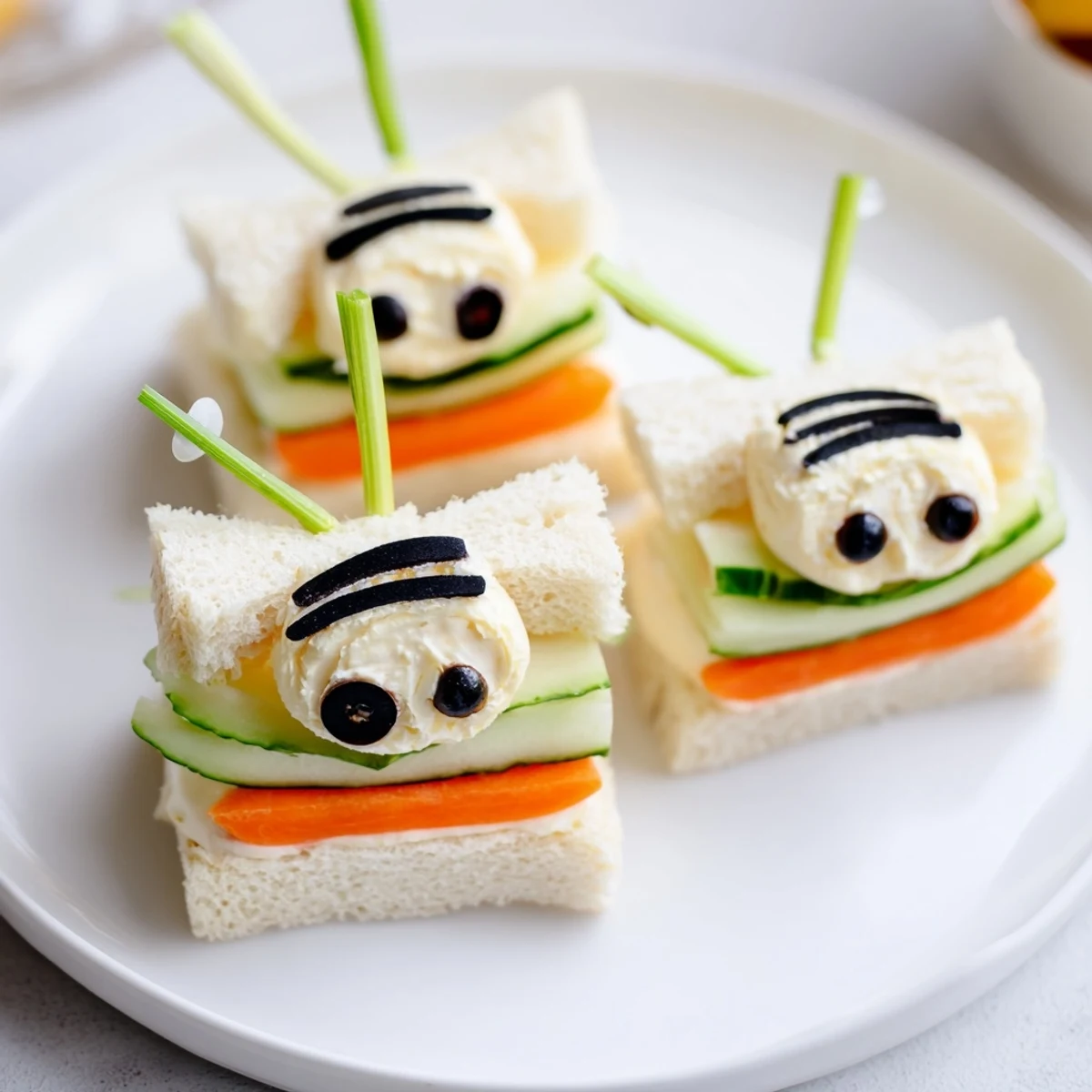 Cute bee sandwiches arranged on a colorful board with fresh fruits and vegetables, ready to eat.