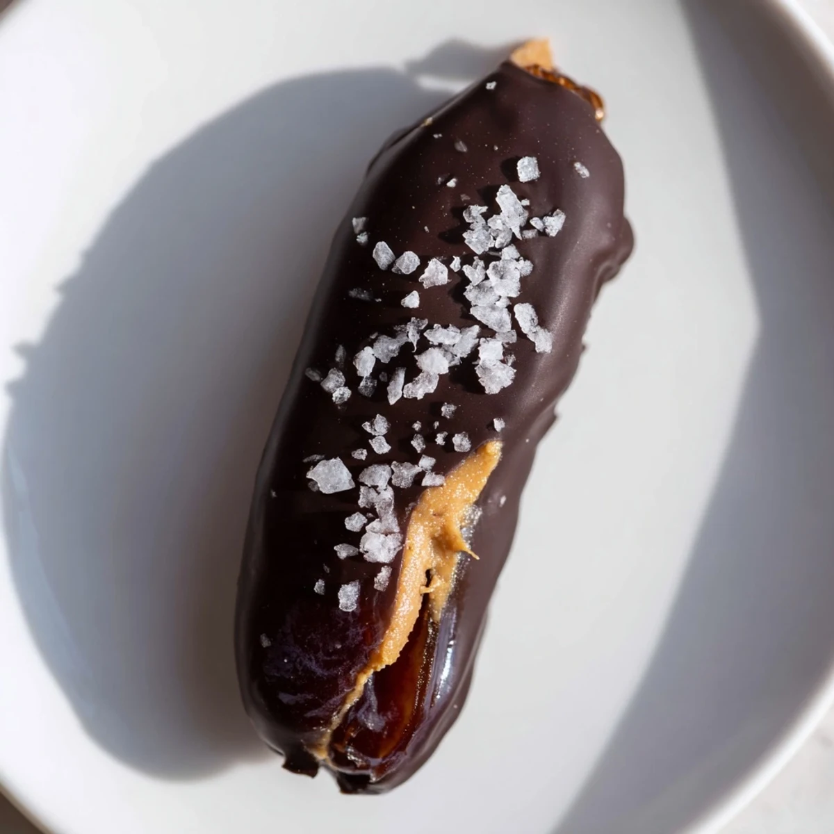 Delectable close-up of chocolate peanut butter dates, a sweet no-bake treat sprinkled with sea salt.