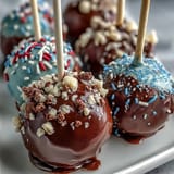 Graduation cake pops in school colors with gold sprinkles, a festive dessert perfect for celebrating academic milestones.
