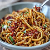 Vibrant chili crisp noodles tossed with crisp vegetables, aromatic garlic, and a bold, umami-rich chili oil sauce.