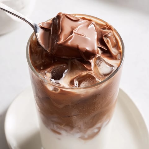 Delicious Chocolate Cracking Iced Latte, featuring a crisp chocolate shell on creamy iced coffee.