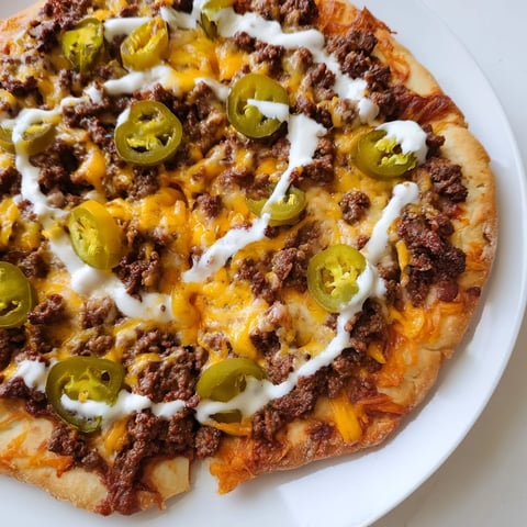 Ground Beef Taco Pizza, melty cheese and spicy jalapeños atop a crispy pizza crust.