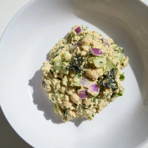 Chunky chickpea tuna salad with crispy celery and onion, perfect for a refreshing lunch wrap.