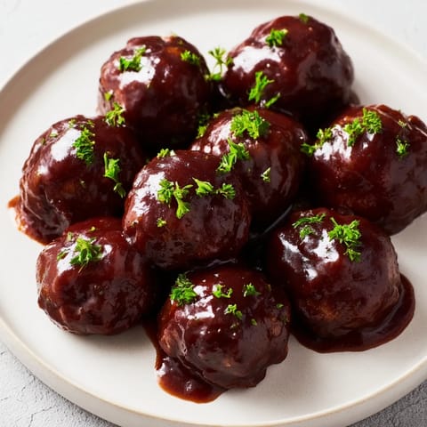 These tender slow cooker cherry BBQ meatballs simmer in a rich, sweet, and smoky sauce, perfect for any gathering.