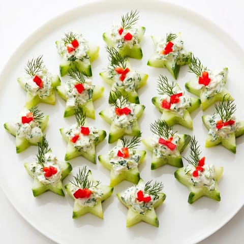 Festive cucumber and dill Christmas Stars glistening, creamy cheese piped on each star's surface.