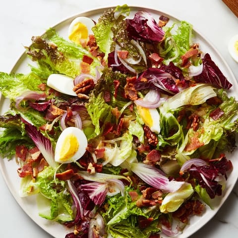 A close-up of a delightful bitter greens salad, coated in flavorful warm bacon dressing and bacon crumbles.