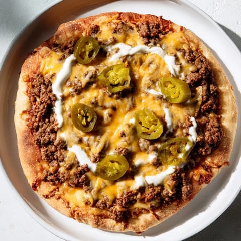 A sizzling close-up showcases vibrant, flavorful Ground Beef Taco Pizza ready to be enjoyed.