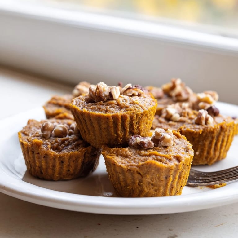 Freshly baked vegan pumpkin muffin tartlets ready to enjoy at festive gatherings this fall.  