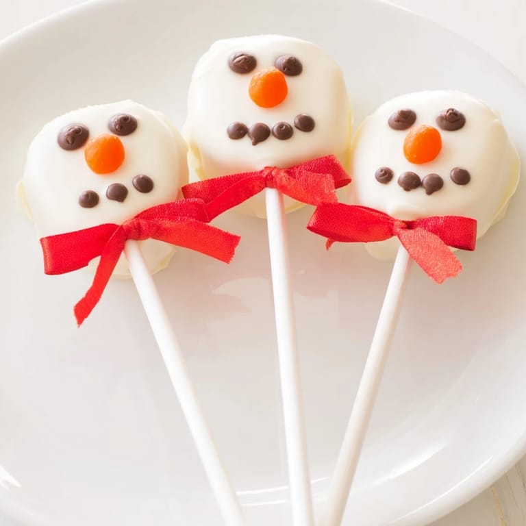 Enjoy these easy-to-make Express Snowman Marshmallow Pops, dipped in white chocolate and ready for a holiday celebration.