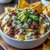Cinco de Mayo Loaded Queso Dip with spicy chorizo and fresh pico de gallo, served warm with crispy tortilla chips.